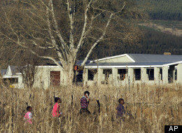In this photo taken Monday, Aug. 8, 2011, children walk past the Umvoti AIDS Centre in Greytown, South Africa. The words of little children from an isolated town in rural South Africa may have stopped an international sex predator. U.S. investigators say Jesse Osmun confessed that as a Peace Corps volunteer, he for months sexually molested at least five girls at a South African shelter for AIDS orphans and other children. (AP Photo/Themba Hadebe)