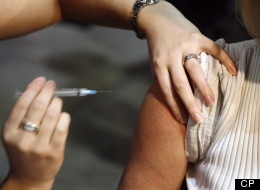 Community Health Nurse Amy Beck injects a patient with a H1N1 vaccine during a flu shot program in Calgary on Oct. 26, 2009. (CP/Jeff McIntosh)