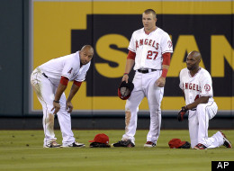 Los Angeles Angels left fielder Vernon Wells, left, center fielder Mike Trout, center, and right fielder Torii Hunter wait for a pitching change during the eighth inning of their baseball game against the Texas Rangers, Wednesday, Sept. 19, 2012, in Anaheim, Calif.