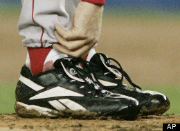 In this Oct. 19, 2004 file photo, Boston Red Sox pitcher Curt Schilling tends to his right ankle during the third inning of game 6 of the ALCS against the New York Yankees in New York.