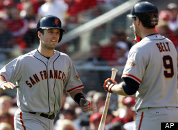 San Francisco Giants' Buster Posey is congratulated by Brandon Belt after Posey hit a grand slam against the Cincinnati Reds in the fifth inning of Game 5 of the National League division baseball series, Thursday, Oct. 11, 2012, in Cincinnati.