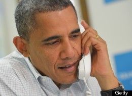 U.S. President Barack Obama speaks on the phone to a volunteer during an unannounced visit to a campaign office October 14, 2012 in Williamsburg, Virginia. (MANDEL NGAN/AFP/GettyImages)