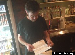 Washington bartender Mike Boone looks over one of the hospital bills he received after suffering multiple stab wounds fighting off a mugger.