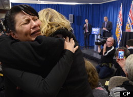 Women hug as Commissioner Wally Oppal (background) delivers the final report of the Missing Women Inquiry in Vancouver, Monday, Dec.17, 2012. (THE CANADIAN PRESS/Jonathan Hayward)