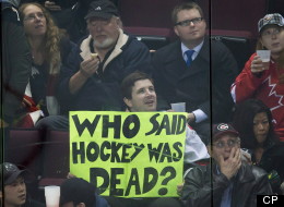 A hockey fan holds up a sign as Team WHL and Team Russia play during the third period in game 5 of the CHL Subway Super Series in Vancouver, B.C., on November 14, 2012. Fans filling the NHL hockey void with football and movies are welcoming its return.THE CANADIAN PRESS/Darryl Dyck