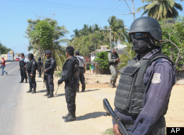State police stand at a roadblock due to stepped up security after masked armed men broke into a beach home, raping six Spanish tourists who had rented the house in Acapulco, Mexico, Tuesday Feb. 5, 2013. According to the mayor of Acapulco, five masked men burst into a house the Spaniards had rented on the outskirts of Acapulco, in a low-key area near the beach, and held a group of six Spanish men and one Mexican woman at gunpoint, while they raped the Spanish women before dawn on Monday. (AP Ph