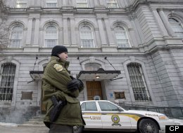 A Sûreté du Québec officer stands outside City Hall in Montreal, Tuesday, Februray 19, 2013, during a raid by officers on the premises. THE CANADIAN PRESS/Graham Hughes.